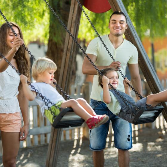 hetero parents with kids on swings