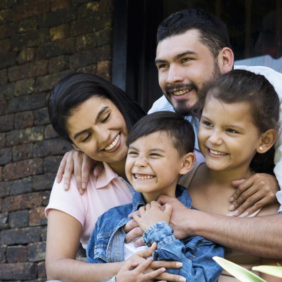Photo of Hispanic family holding two young children