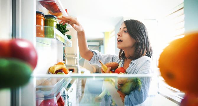 mother picking fruits & veggies from refrigerator